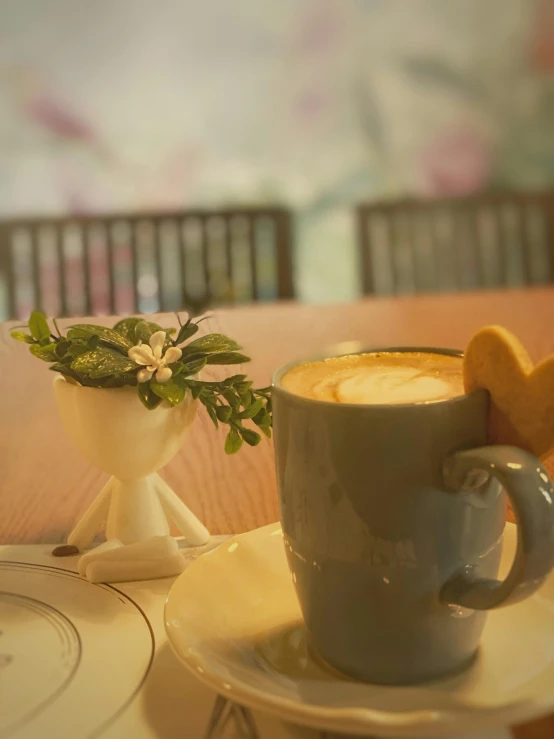 a cup sitting on top of a white plate near a cup of coffee