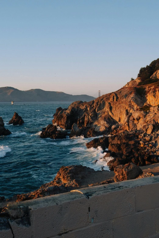 the ocean waves break near a rocky coast