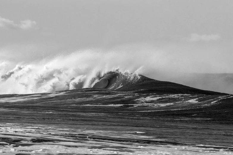 a large wave crashing over the top of a mountain