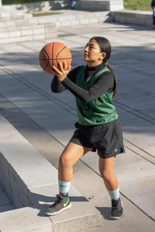 a woman is tossing the basketball up in her hands