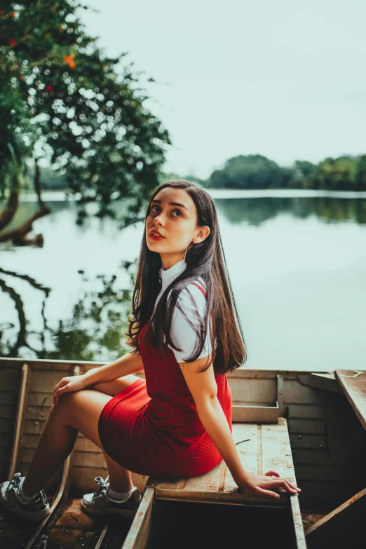 a woman is sitting in a rowboat by the water