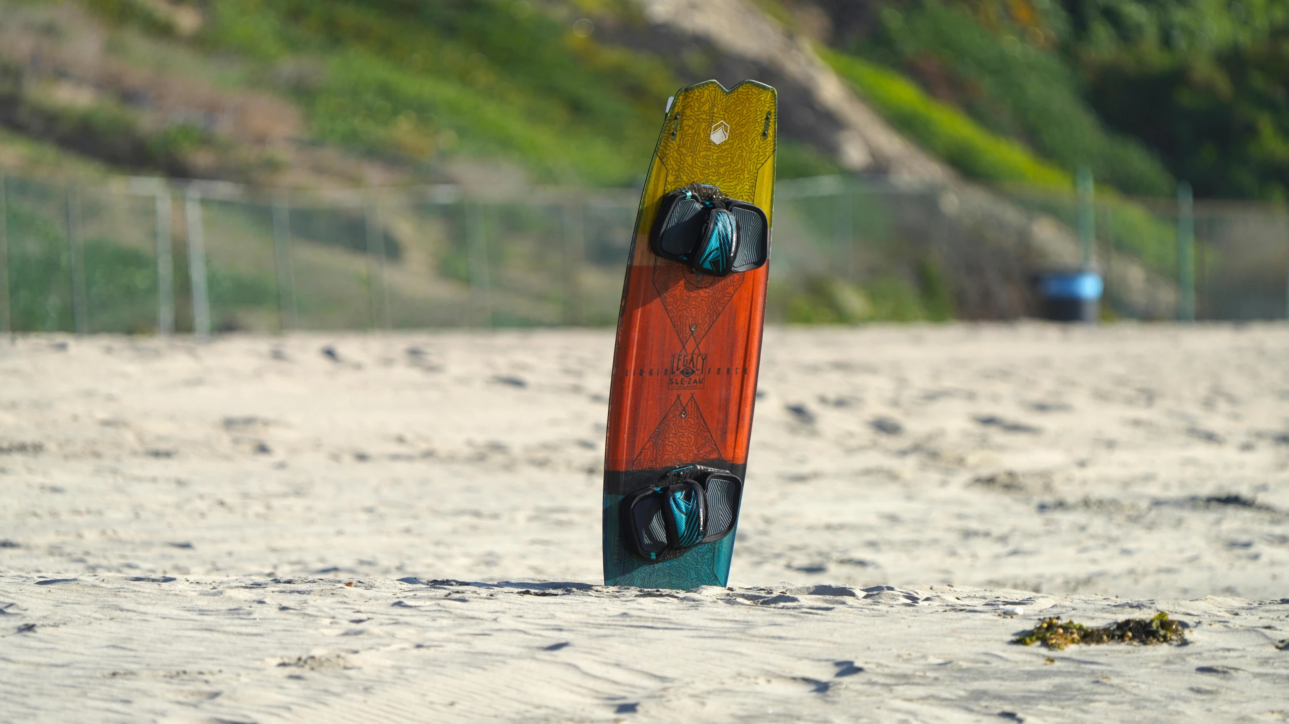 an orange surfboard sticking out of the sand