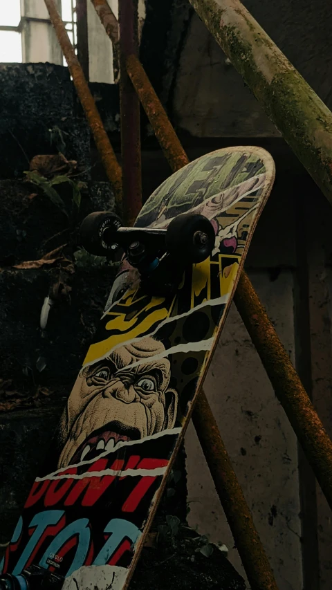 a colorful skate board sits under some old rusted stairs