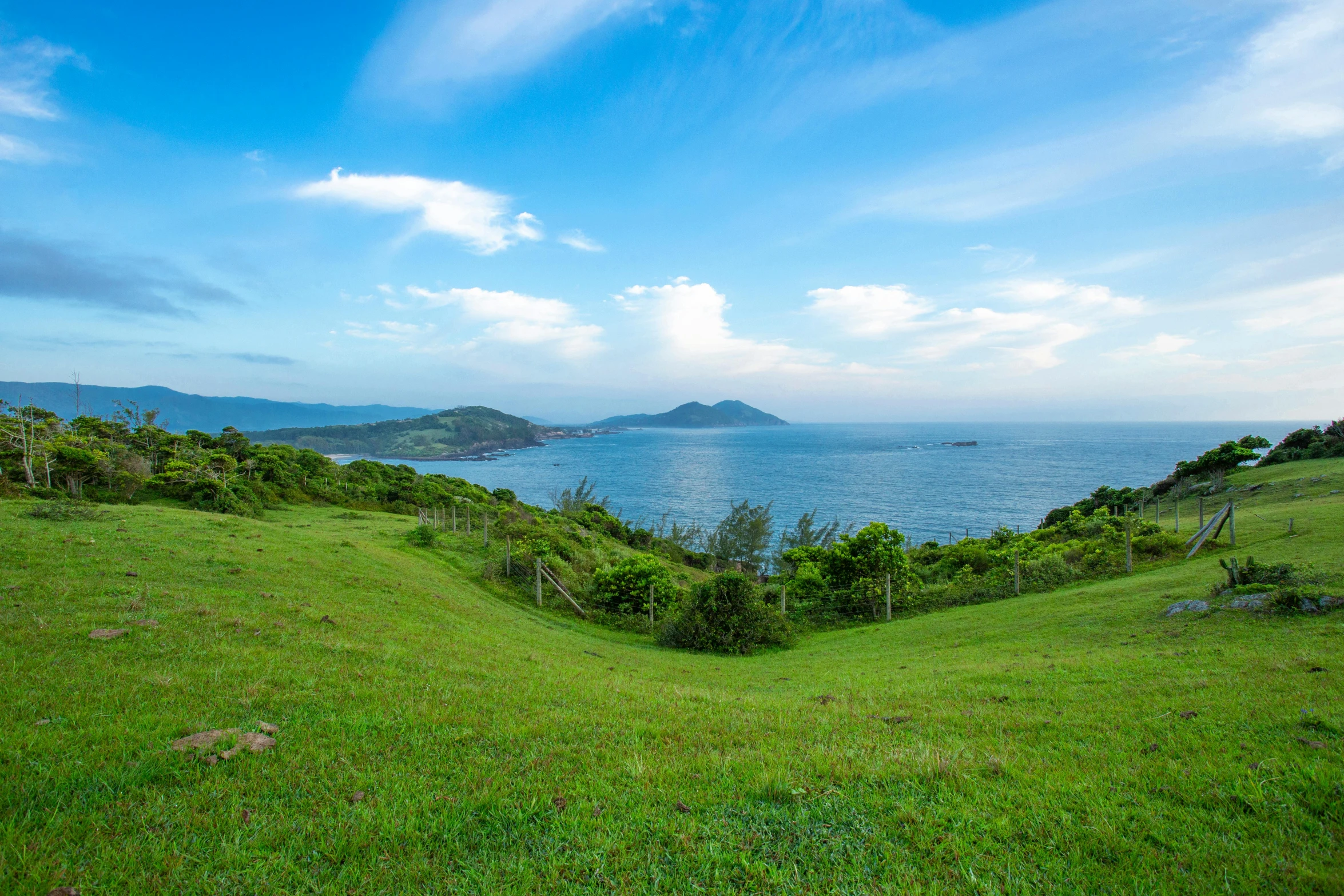 a green hill overlooking the ocean with an ocean view