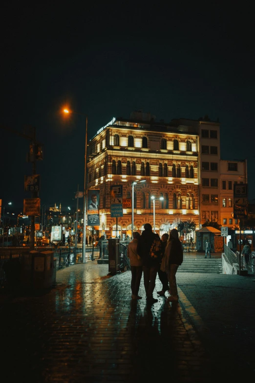 three people walking down the road in the rain