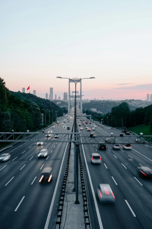 several cars driving on highway next to a city