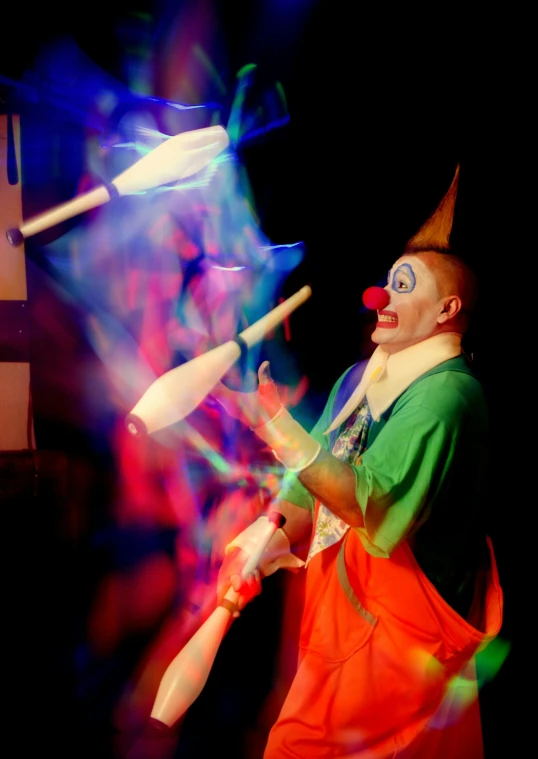 a clown performs a trick on a toy in front of colorful lights