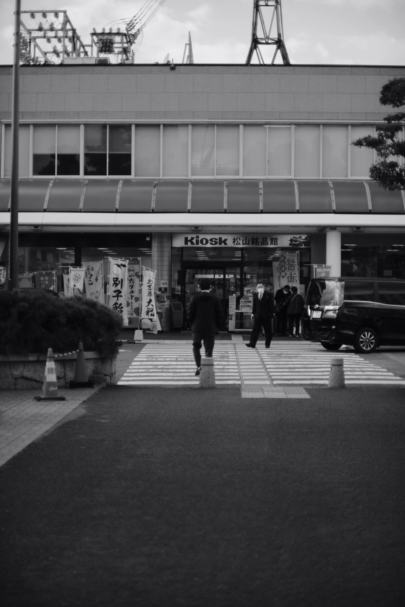 a black and white po shows people walking outside of a building