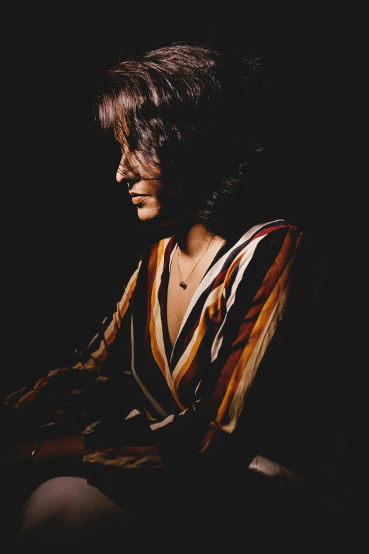 a woman is shown sitting on the floor in a dark room