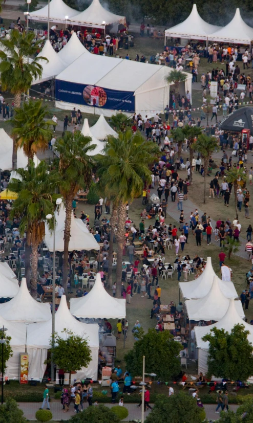 an aerial view of many tents with trees and people