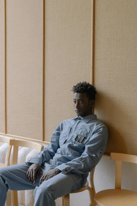 a man sitting on a chair against a wall