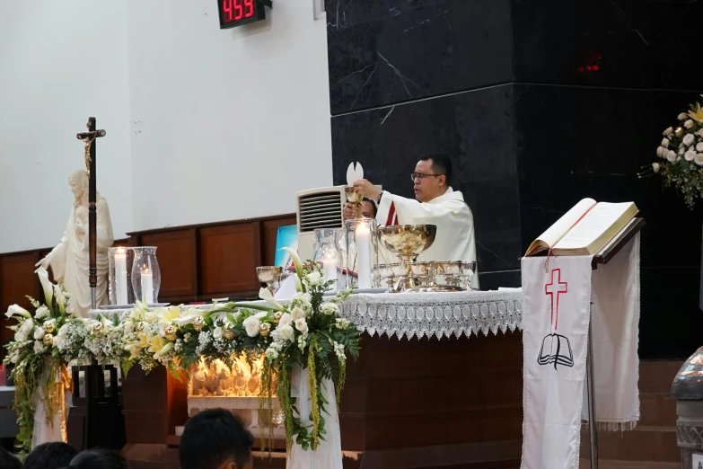 a man on a church altar gives a speech to people