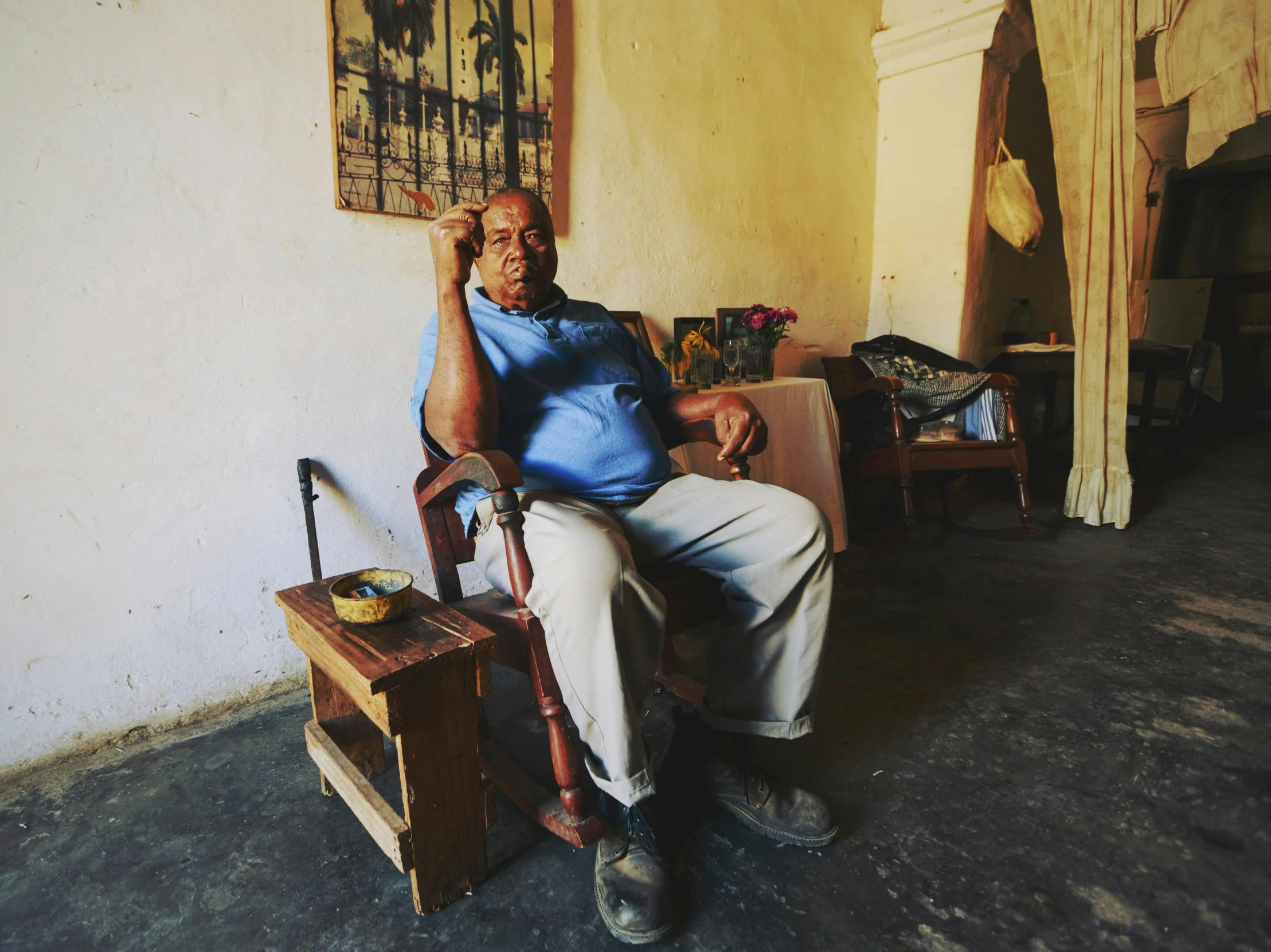 an elderly man sitting in a chair in front of a window