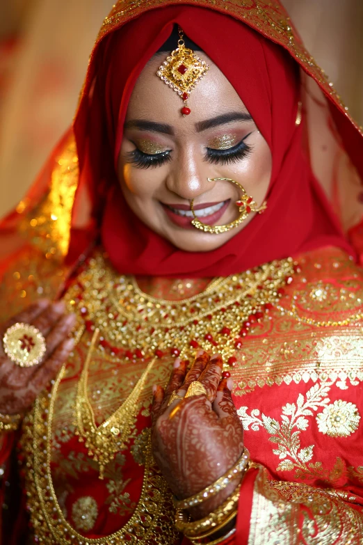 a woman wearing red and gold with gold details around her face