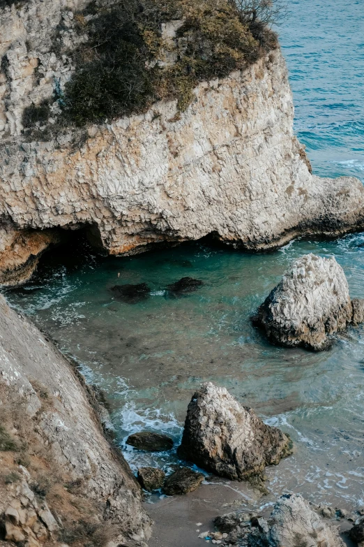 two large rocks are at the edge of the water