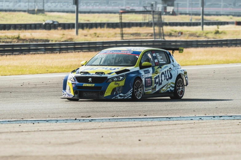 a rally car races around a track with yellow paint