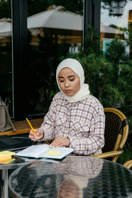 an image of a woman sitting at a table taking notes