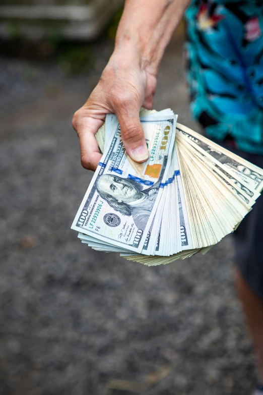 a man holding a bunch of money in his hand