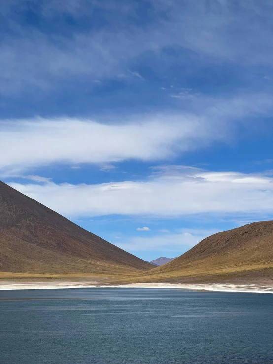 a body of water with hills on the horizon