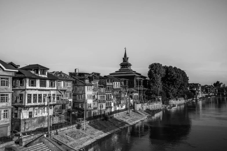 black and white pograph of buildings overlooking water at dusk