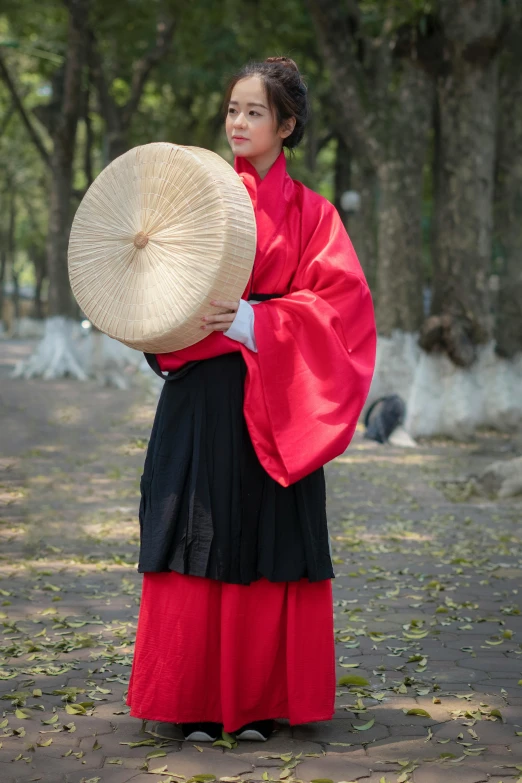 the woman is dressed in traditional garb and holding her hat