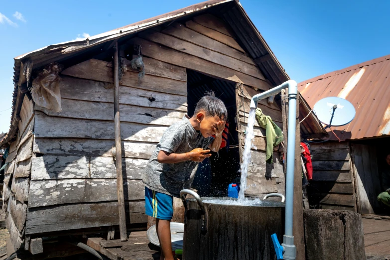 a man using an open metal water faucet