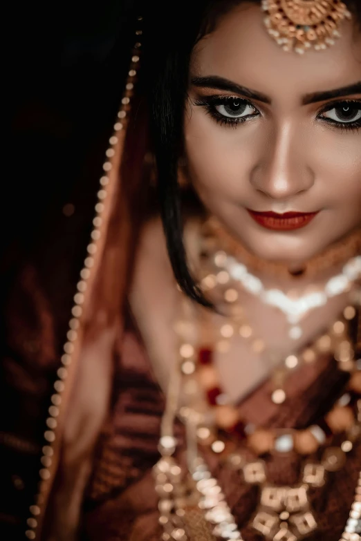 a woman wearing a bridal outfit with beads on her head