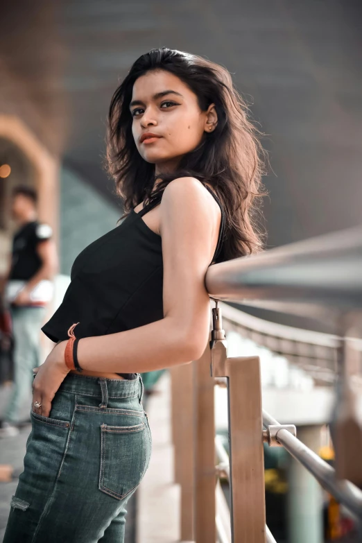 a woman standing against a rail near an airport