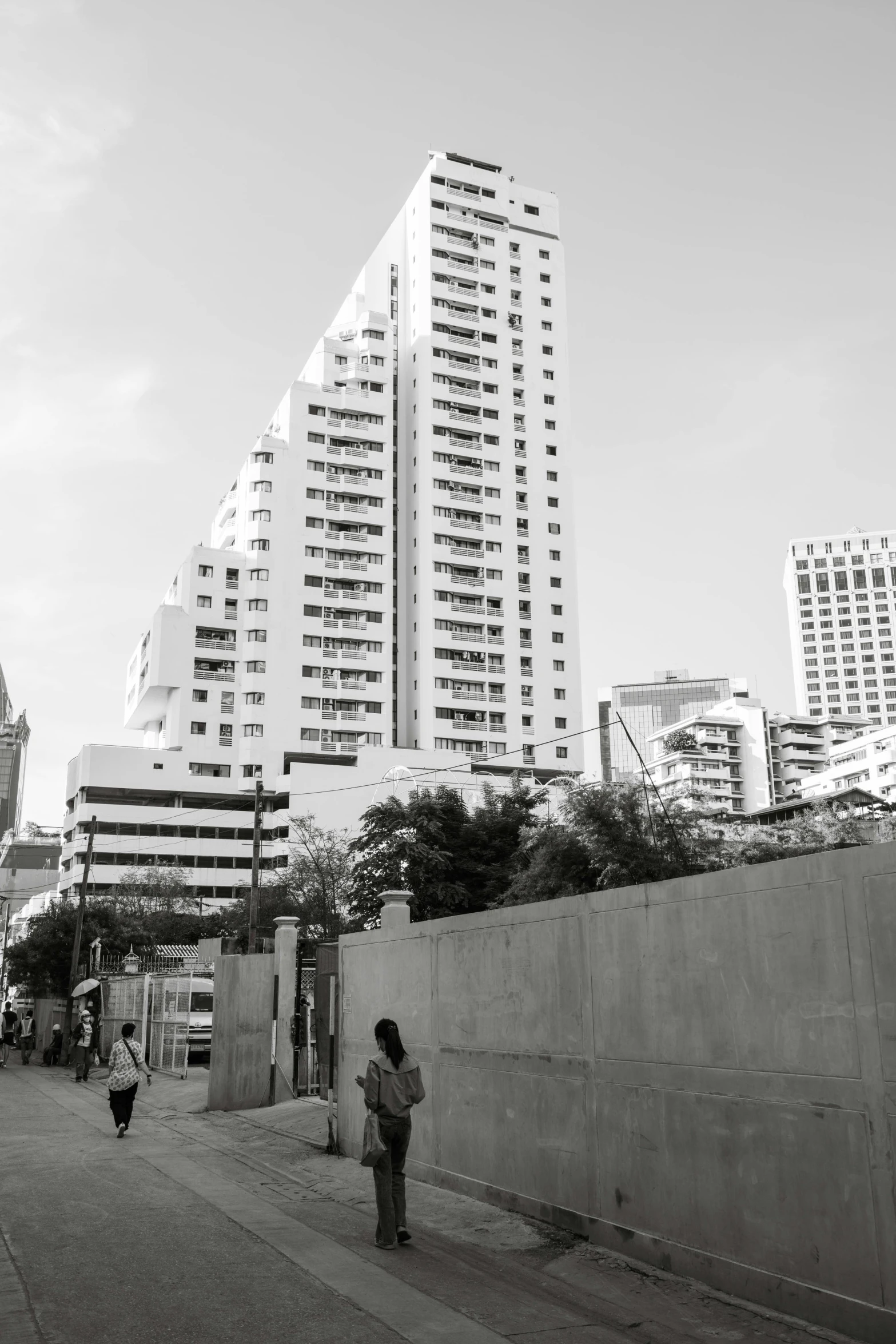 a black and white po of a woman standing on a sidewalk