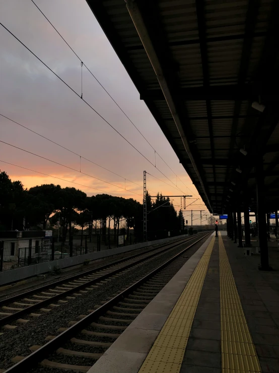 a train platform has multiple sets of tracks in front of the train station