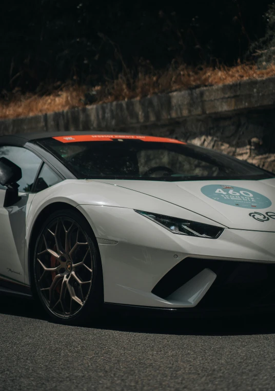 a white sports car with a racing sticker on the side of it