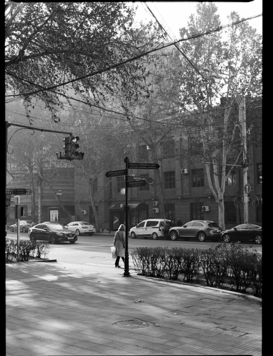 person walking down a sidewalk at night under the street lamp