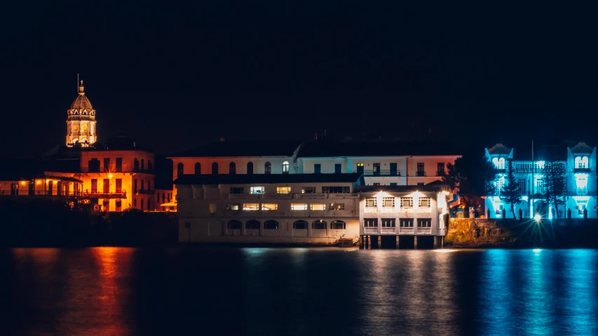 a row of houses near the water at night