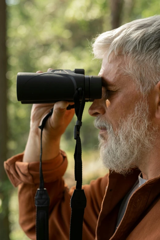 a man with grey hair and glasses holding a camera