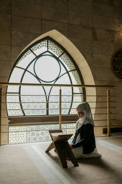 a woman sitting on a bench in front of a window