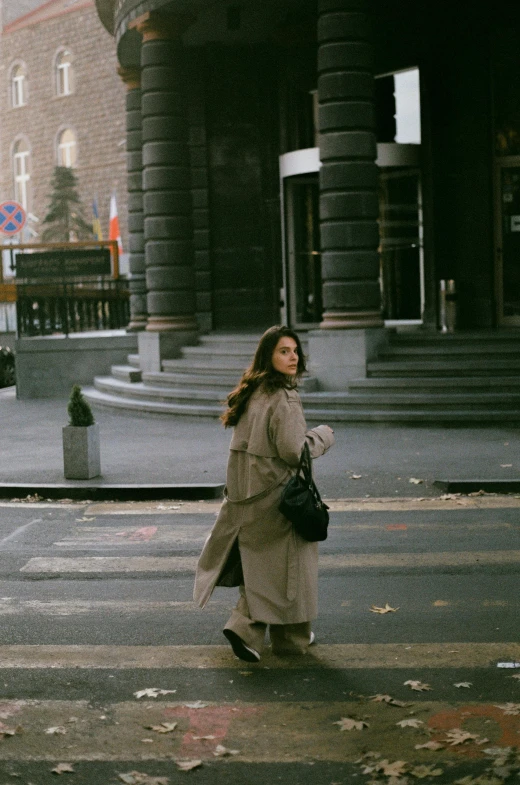 a woman crosses the street in front of the building