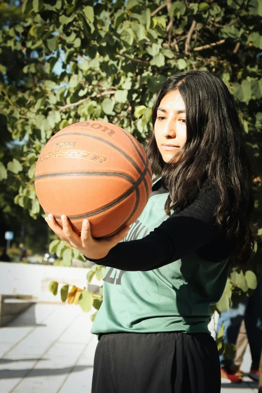 the woman is holding up a ball with a lot of space between her hands