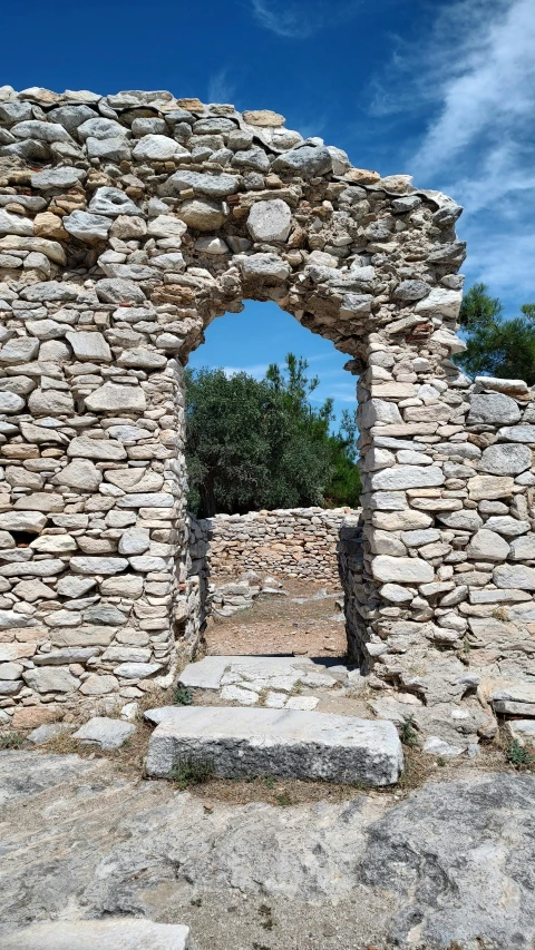 an old stone house surrounded by rocks and trees