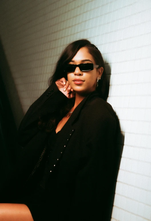 a woman leaning against a wall talking on a cell phone