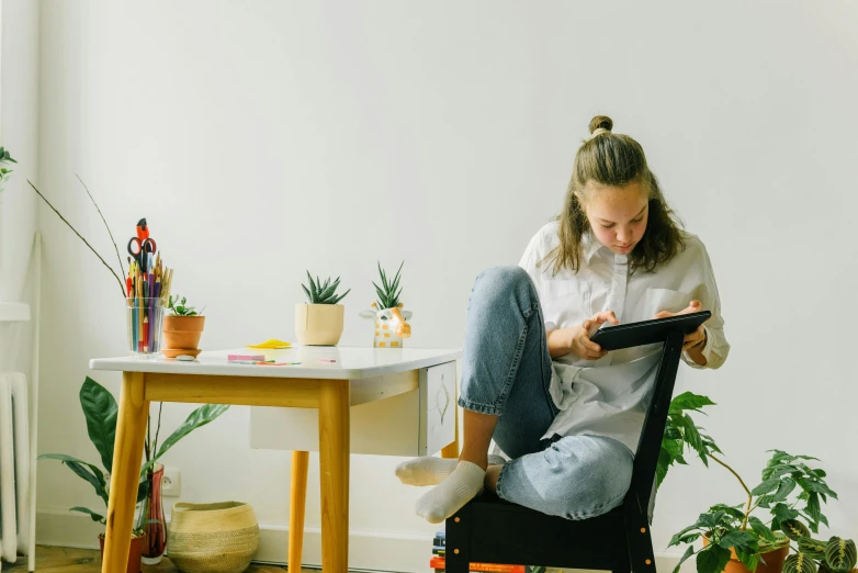 a woman with an electronic device sitting in a chair