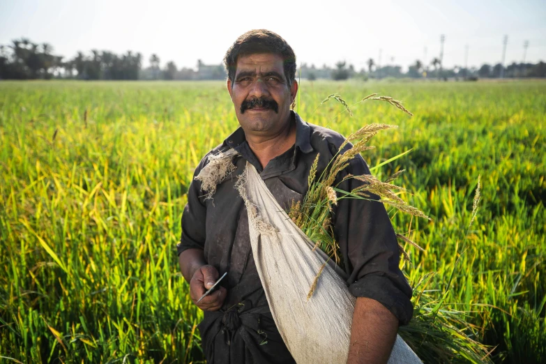 a man with a mustache and mustache holding some plants