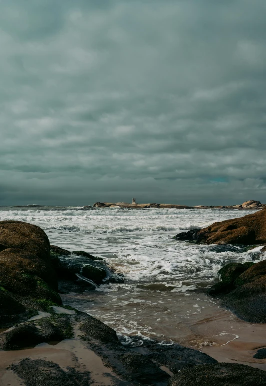 two rocks next to each other near the ocean