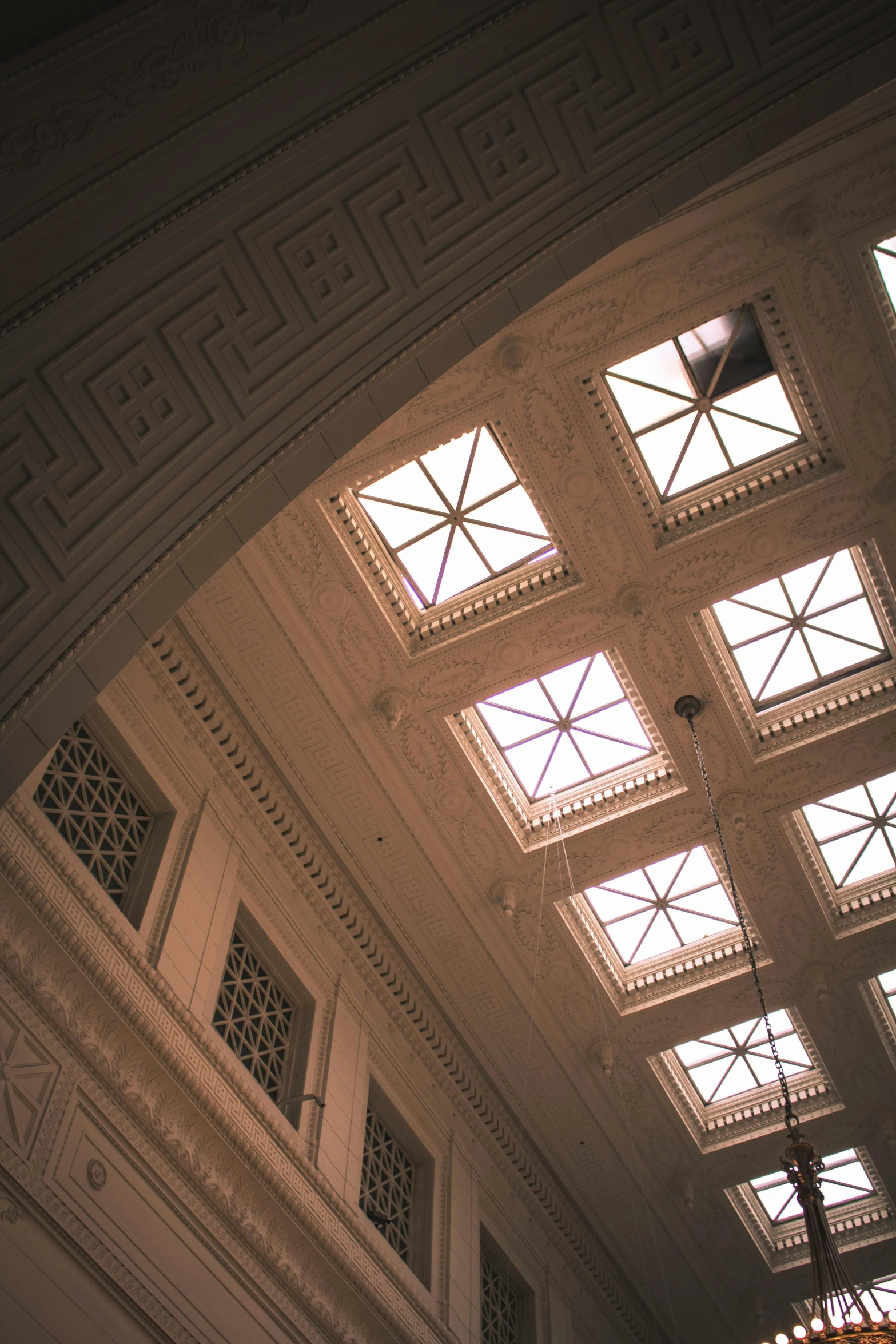 sunlight coming through three windows in an ornate building