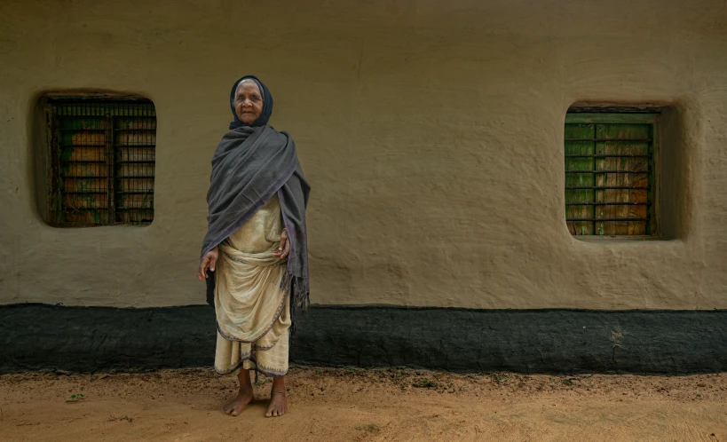 a woman standing in front of a building with two windows