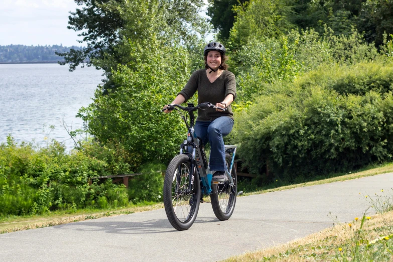 the lady is riding her bike with a helmet on