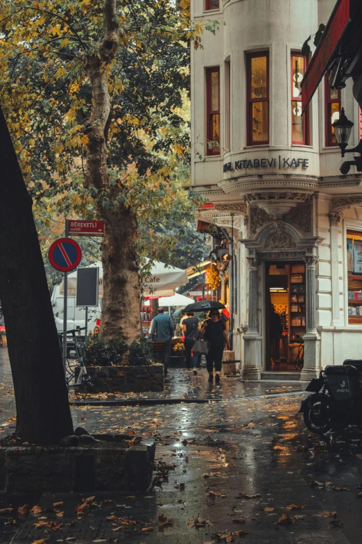 a couple walk down a city street during the rain