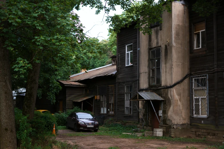 a car parked outside an old brown house