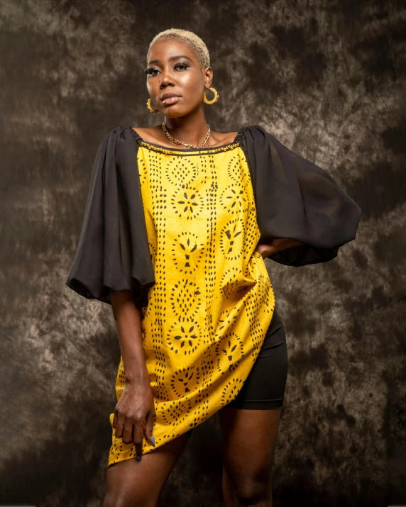 a woman posing with a yellow dress and ear rings