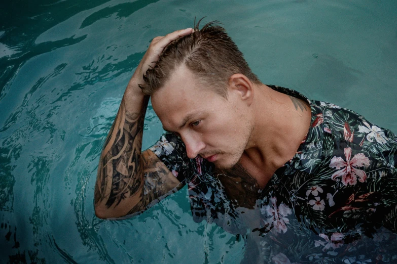 a man with a tattoo on his arm floats in the pool