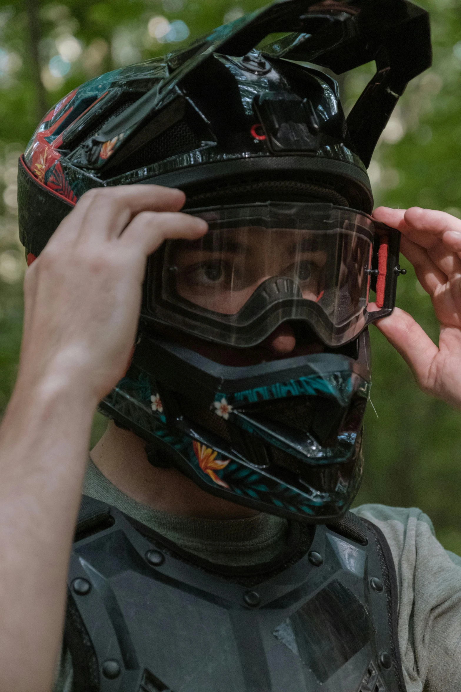 a man holding up his helmet to the vise on his helmet